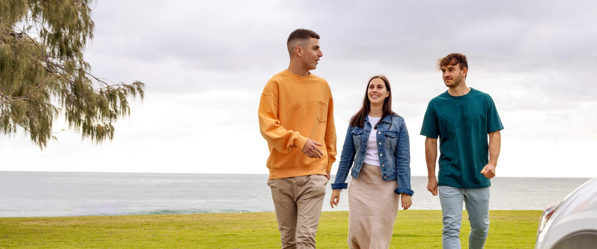 Three people chatting and walking near the beach