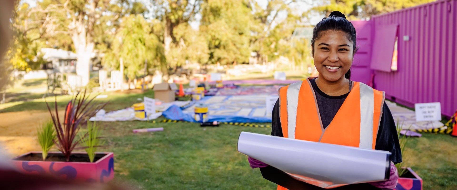Young participant smiling whilst looking at project plans