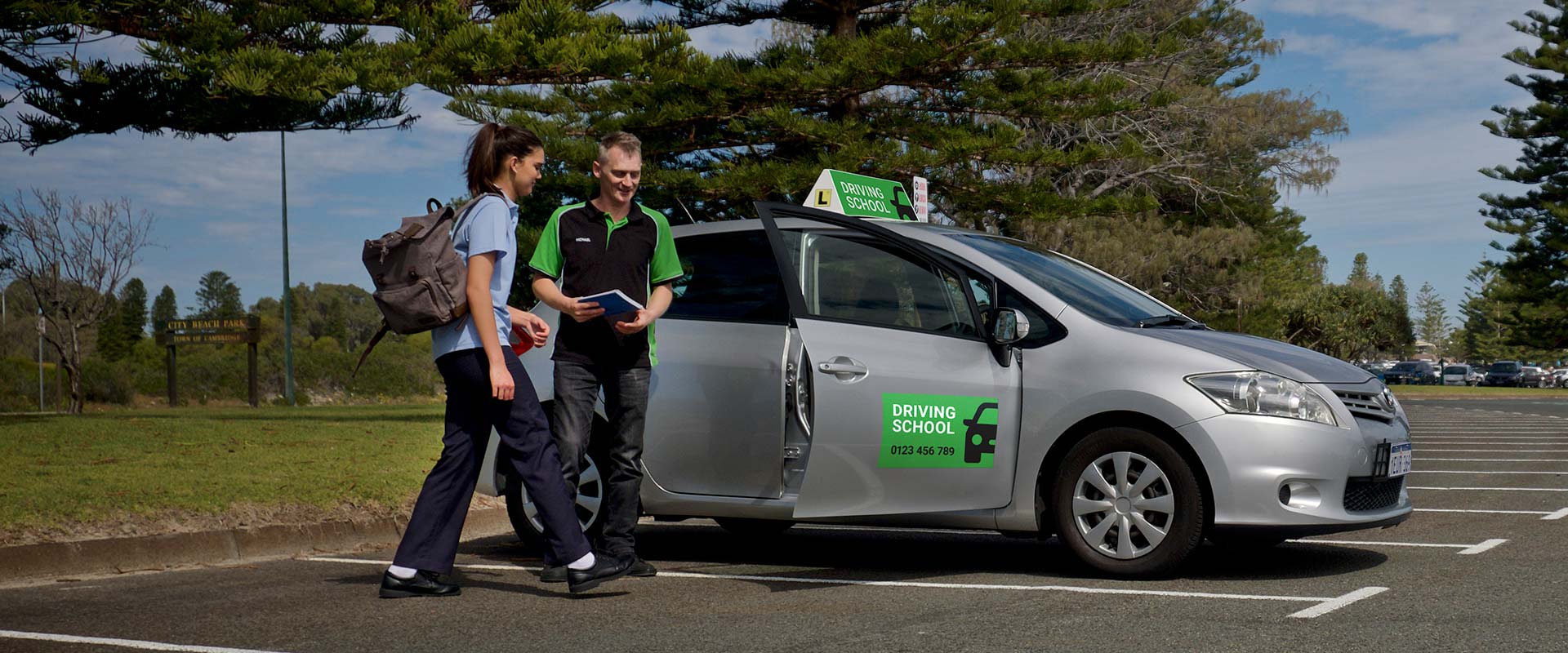 Driving instructor and student entering a parked car to begin their lesson