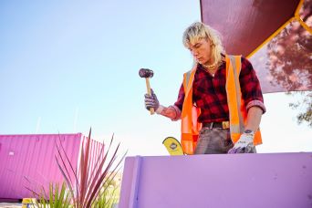 Youth participant holding a hammer building project furniture
