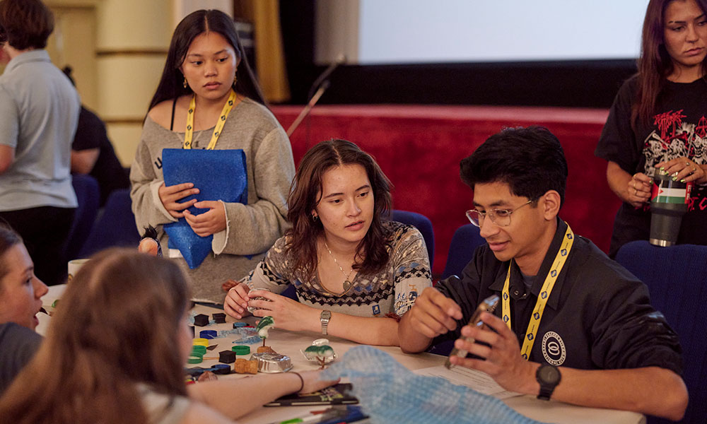 A group of people are surrounding a table together 