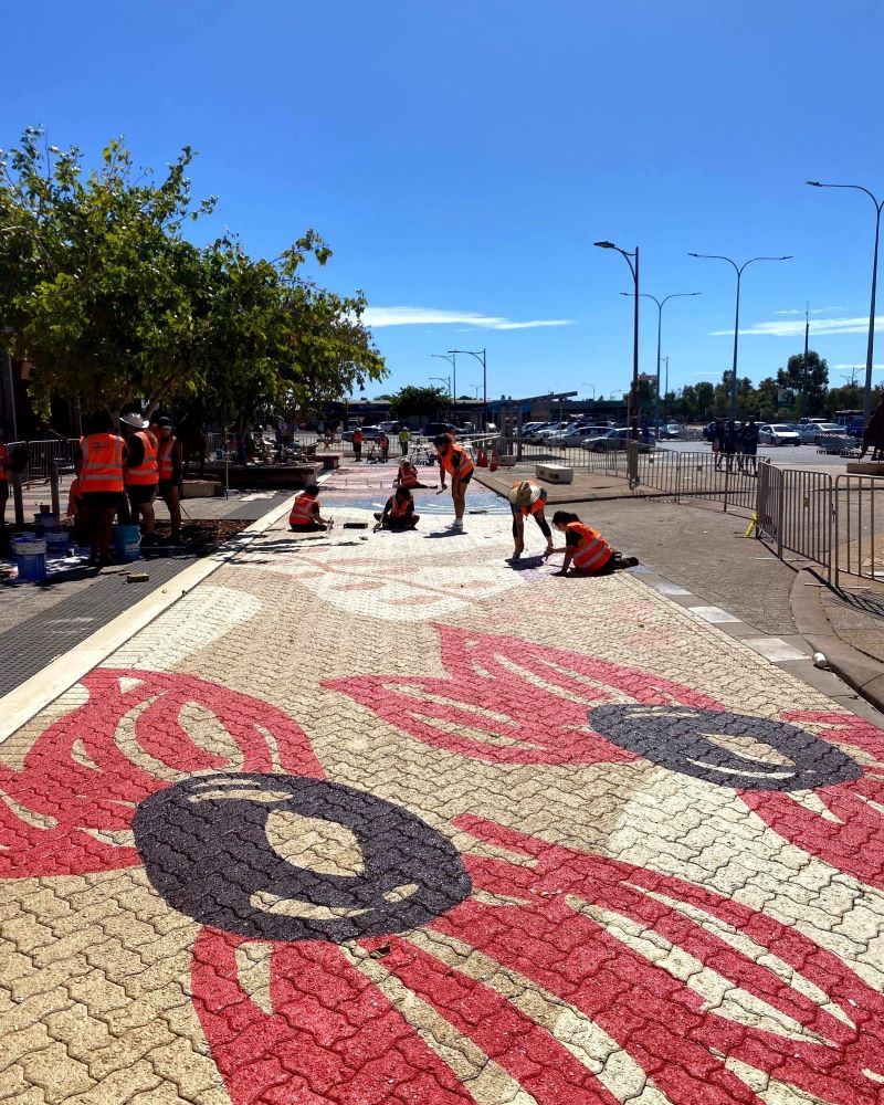 Local young people at work painting elements of their road mural