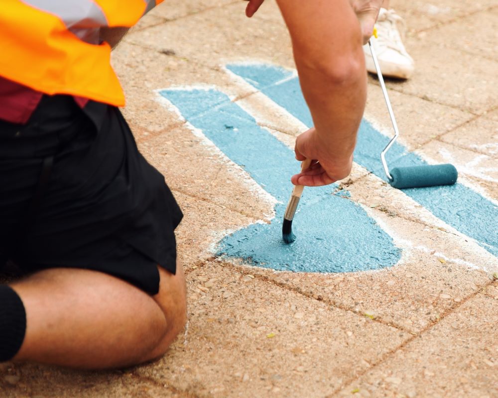 Local young people painting animal tracks on the pavement
