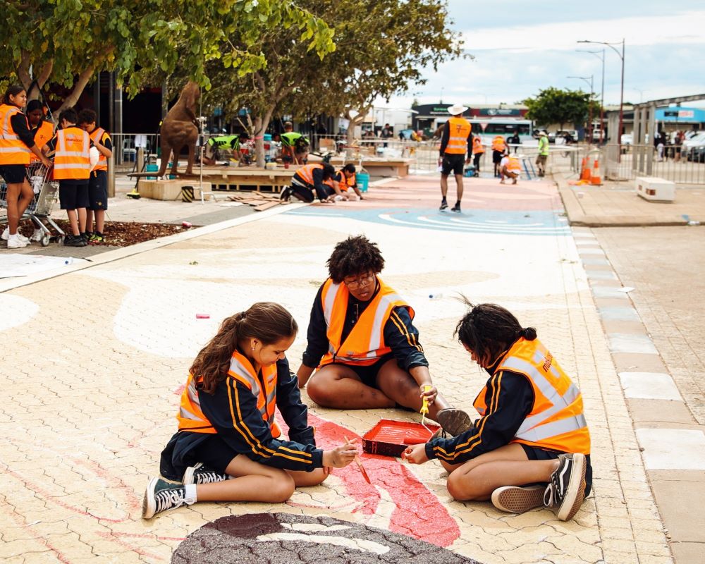 Local teens paint dessert peas on the Wise Terrace road mural