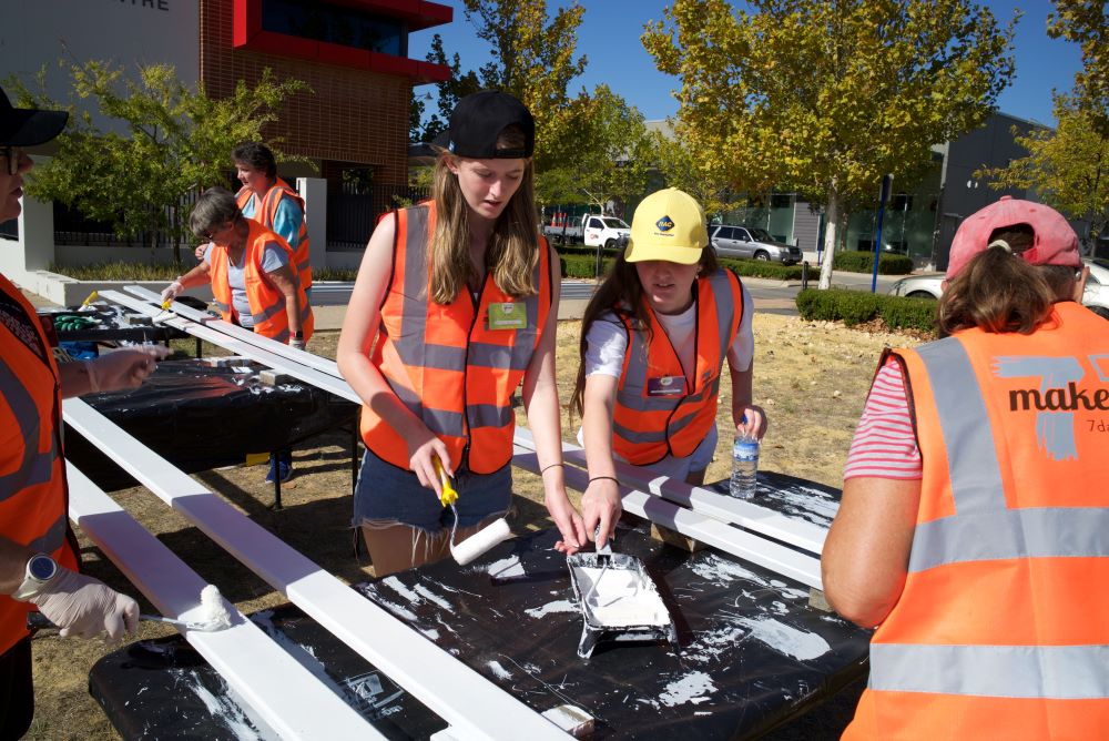 Local young people painting furniture panels