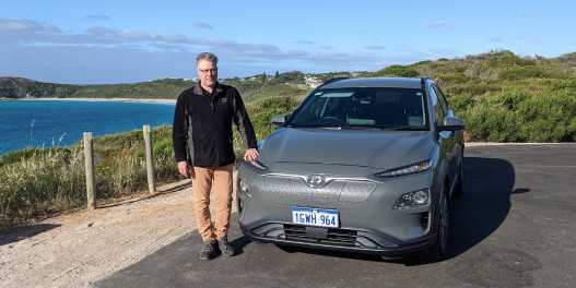 Ant standing next to his electric car