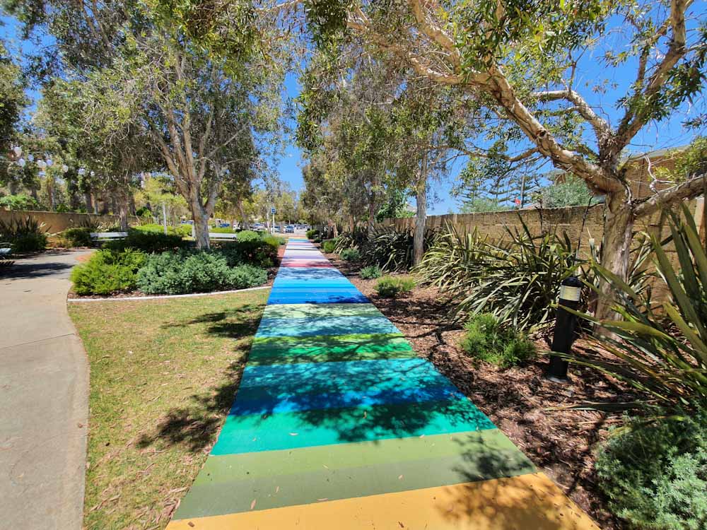 A footpath in Mandurah painted in a variety of coloured stripes