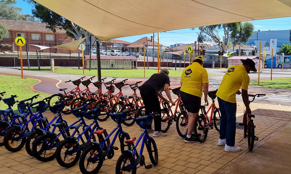RAC volunteers assist in setting up rows of children's pushbikes,