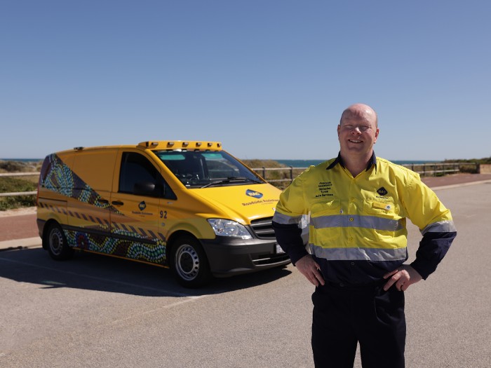 RAC patrol driver standing in front of iconic RAC yellow patrol van in car park