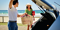 A couple unpacking their car for a day at the beach
