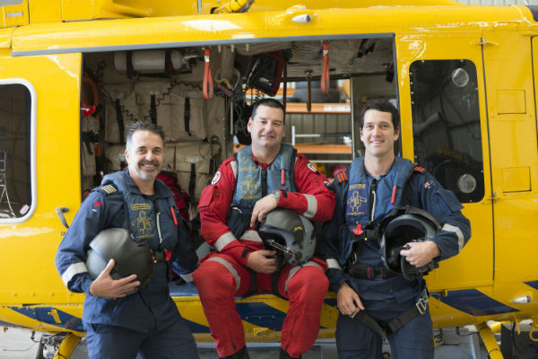 Group photo of the pilot, air crew and paramedic standing in front of the RAC Rescue helicopter