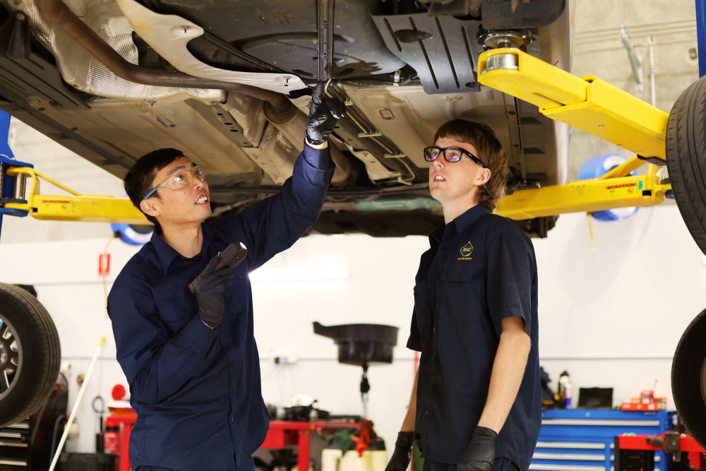 Two RAC mechanics inspecting a vehicle