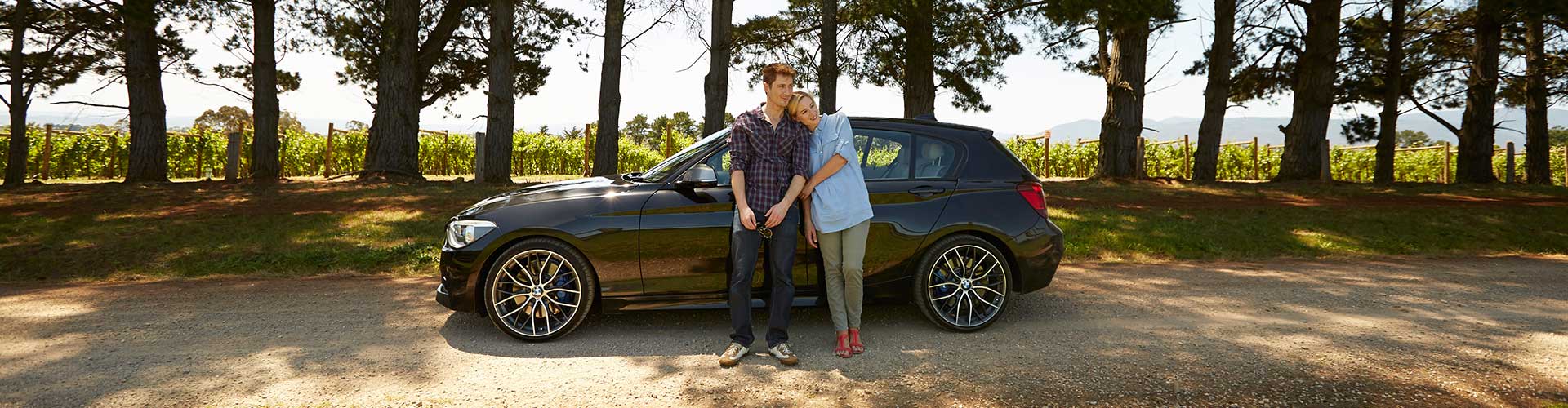 Couple standing by their car.