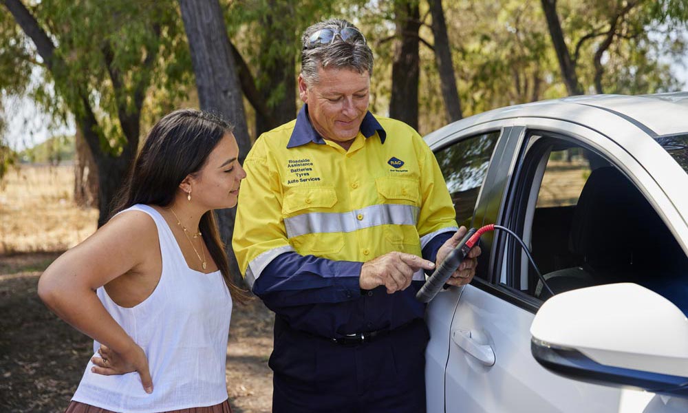 An RAC Roadside Assistance patrol speaking to an RAC member whose car has broken down