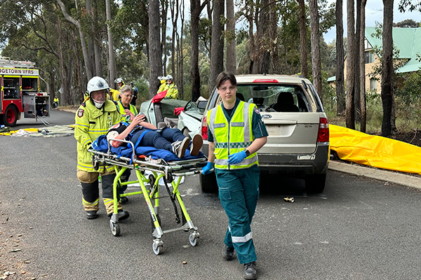 Paramedics wheeling a patient on a stretcher. 