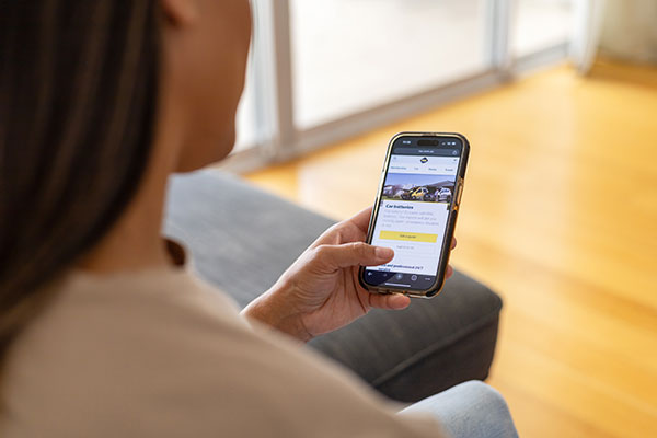 A woman is holding a smartphone in her left hand