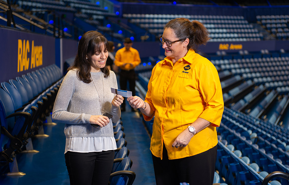 An RAC Arena employee is looking at a patron's ticket
