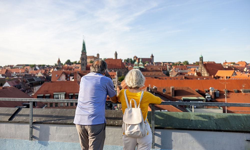 A couple are looking out over rooftops in Germany