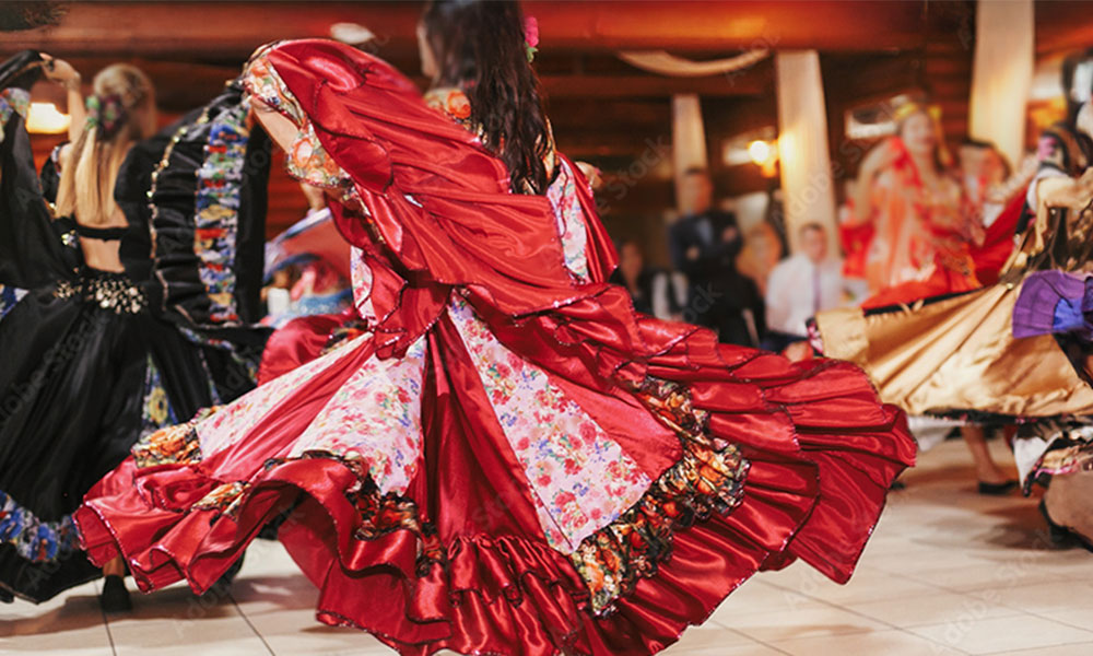 A woman is dancing in a flowing red dress