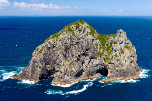 A rock formation called Hole in the Rock in the middle of the deep blue ocean