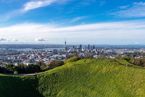 View over Auckland city skyline from a grassy hill, with the Sky Tower in the centre.