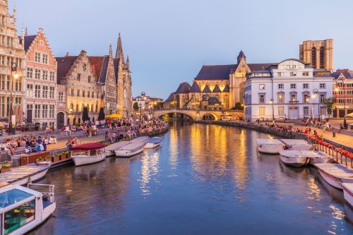 Old town of Ghent by dusk reflecting lights in the canal