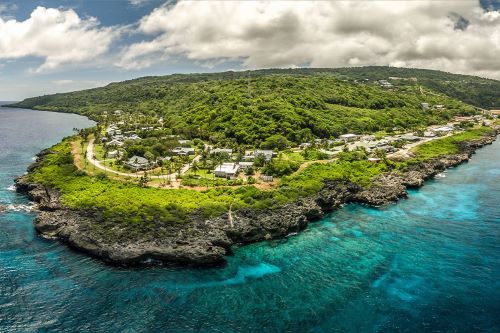 Aerial view of Flying Fish Cove on lush Christmas Island surrounded by turquoise water
