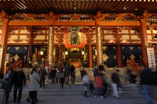 Visitors entering Senso-ji Temple beneath a giant lantern in Tokyo.