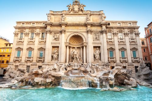 Trevi Fountain in Rome, featuring ornate Baroque architecture, marble sculptures and cascading turquoise water.