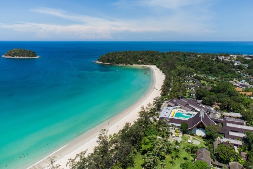 Aerial view of the resort featuring a long white sandy beach and wide views of the ocean