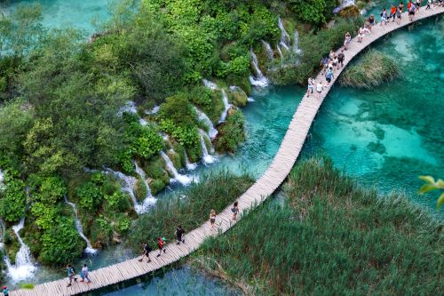Aerial view at wooden hiking path through water besides waterfalls in Plitvice Lakes National Park