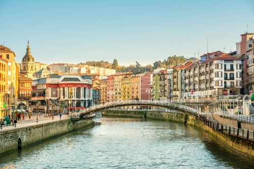 Bilbao riverside with arched bridge and colourful historic buildings