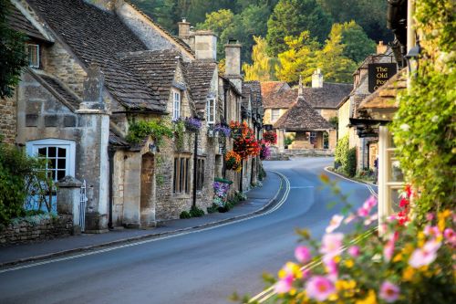 A winding road lined with medieval houses leading through charming Castle Combe.