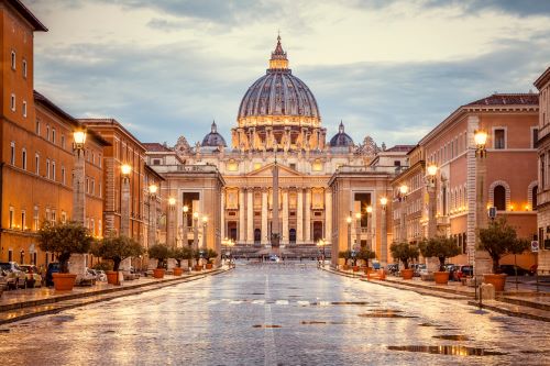 Rainy streets of Rome leading to the St. Peter's Basilica in the background. 