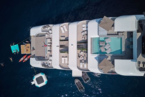 An aerial view of a luxury yacht back deck with the marina platform and activites