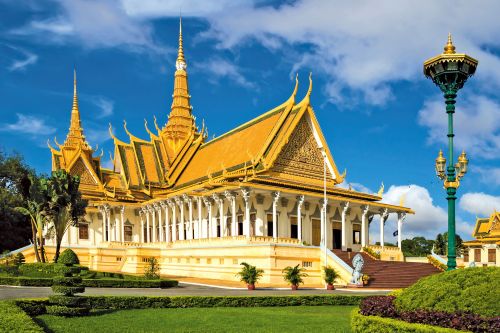 A bright yellow and gold palace surrounded by near green gardens