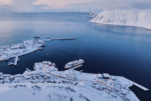 Aerial view of a snowy coastal town with a docked cruise ship