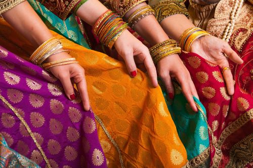 Close-up of female hands showing their colourful saris. 