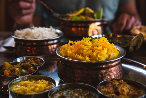 Close-up of a set table with a bowl of saffron rice and other traditional dishes. 