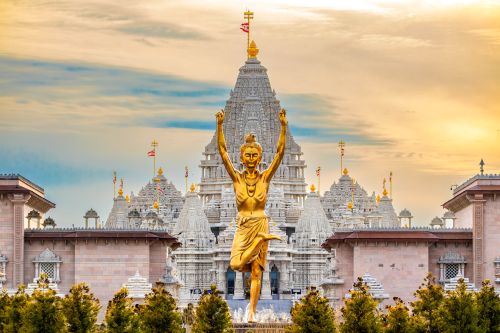 Statue of Nilkanth Varni with Akshardham Mahamandir temple in the back.