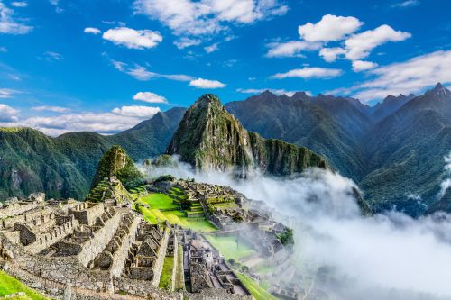 Machu Picchu ruins surrounded by clouds and mountain scenery
