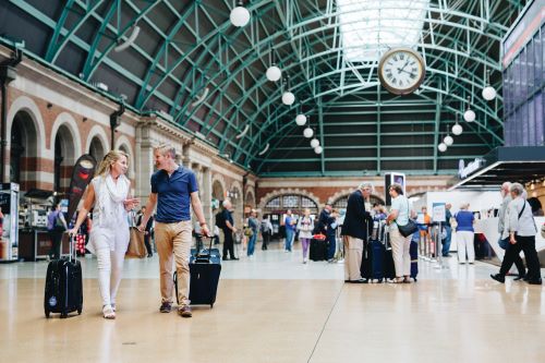 Guests have arrived in Sydney and are walking with suitcases through the Central Station
