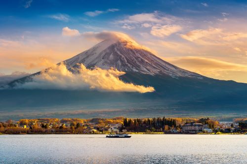Fuji mountain and Kawaguchiko lake surrounded by Autumn coloured leaves at sunset. 