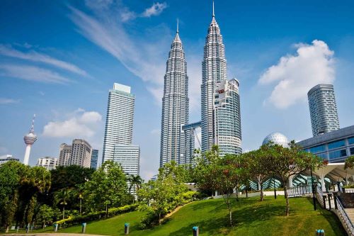 Two large towers with lush greenery in the foreground
