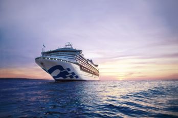 Princess cruise ship at sea against a purple-coloured sunset sky