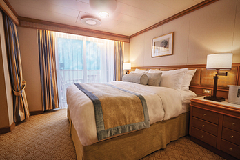 Big and comfortable made-up bed in a stateroom with balcony 