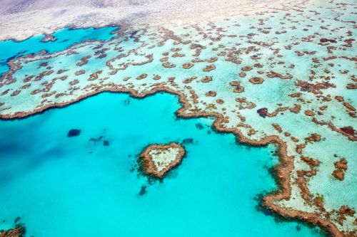 Aerial view of the Great Barrier Reef with bright blue water and the reef