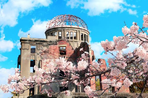 A memorial shrine building with cherry blossoms in the front
