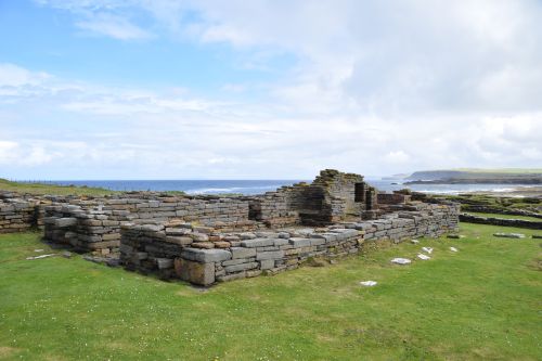 Stone ruins on a grassy coastline overlooking the sea