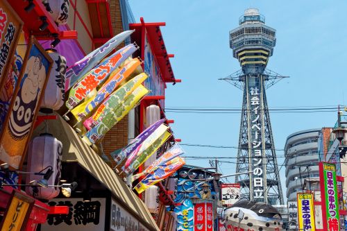 A tall tower lining the skyline with bright coloured buildings in the foreground 